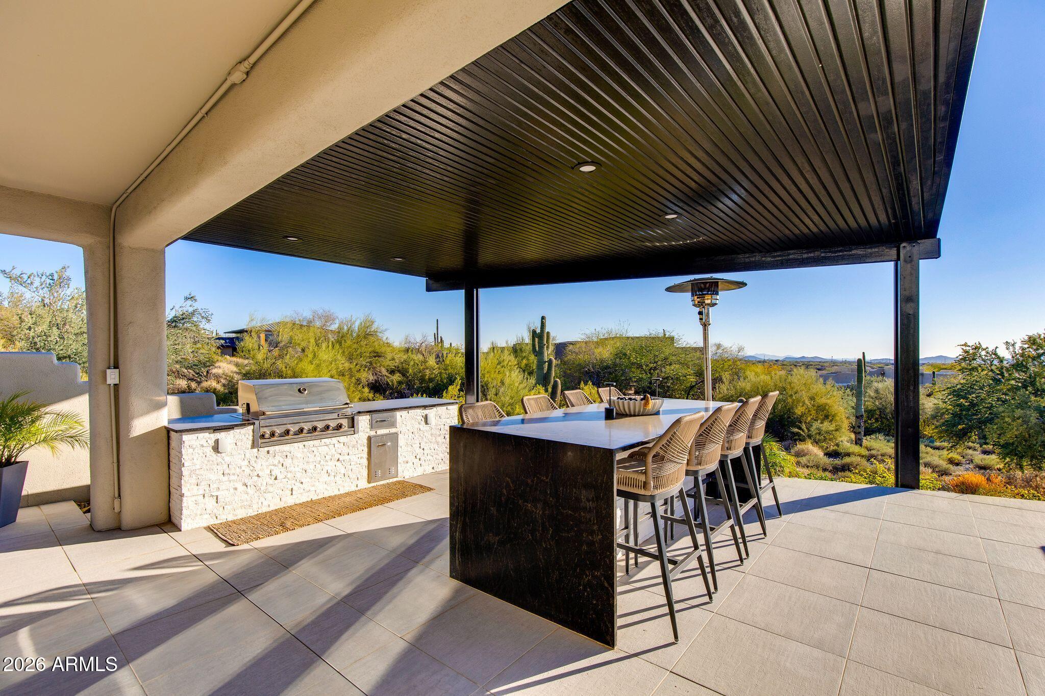 5901 East Restin Road Cave Creek, AZ 85331 - Photo 81 of 101 a view of a patio with a table and chairs under an umbrella