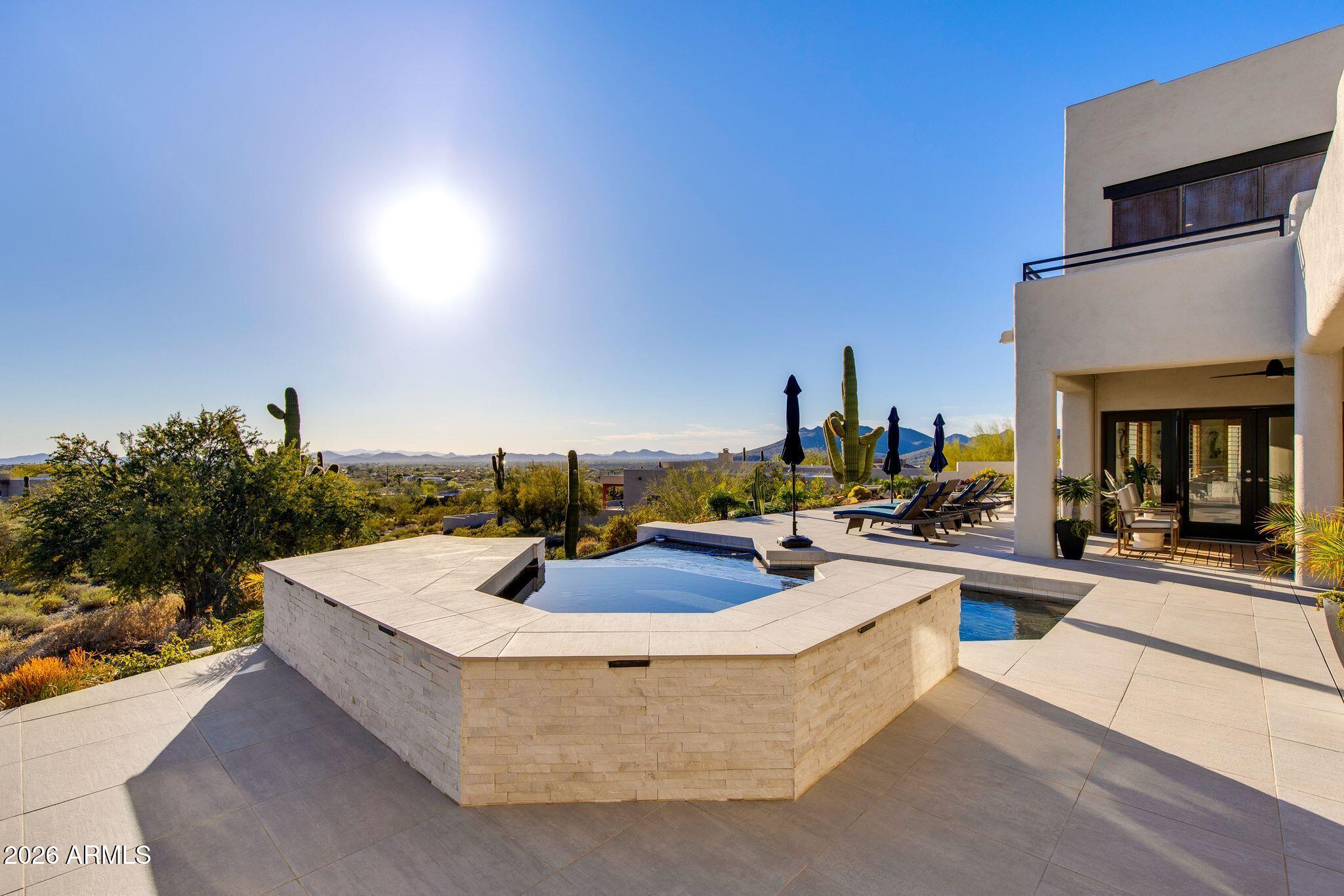 5901 East Restin Road Cave Creek, AZ 85331 - Photo 84 of 101 a view of a swimming pool with couches and potted plants