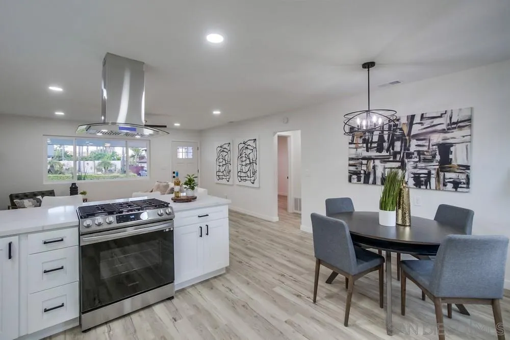 1839 Yettford Road Vista, CA 92083 - Photo 14 of 42 a kitchen with a stove dining table and chairs