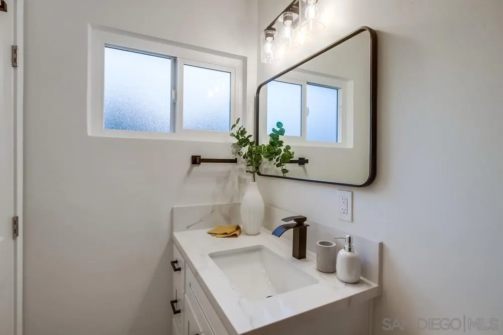 1839 Yettford Road Vista, CA 92083 - Photo 30 of 42 a bathroom with a sink and a mirror