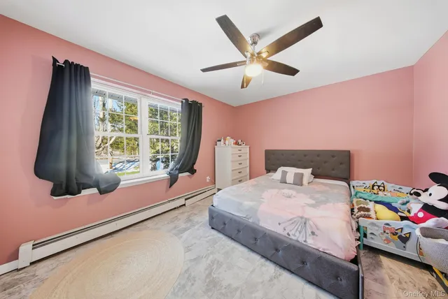 a bedroom with a bed and a flat tv screen on dresser