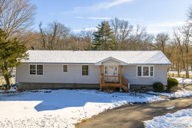 a view of a house with a yard covered in snow