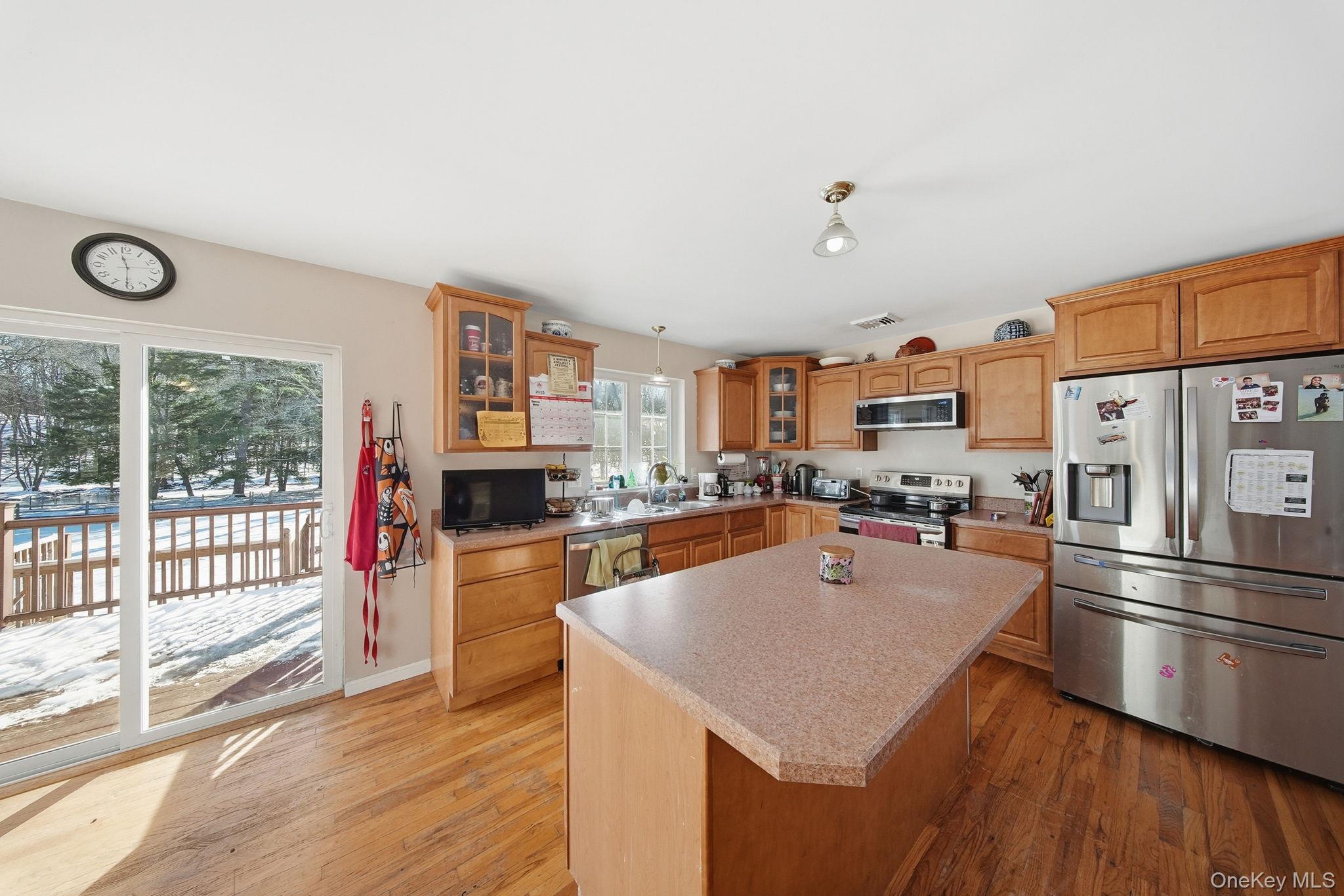 100 Maybrook Road Campbell Hall, NY 10916 - Photo 7 of 32 a kitchen with stainless steel appliances granite countertop a refrigerator a sink dishwasher a stove and a dining table with wooden floor
