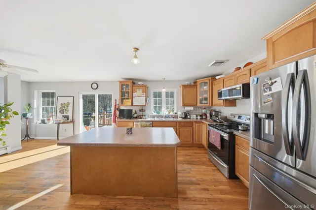 a large kitchen with stainless steel appliances granite countertop a large window and a counter top space