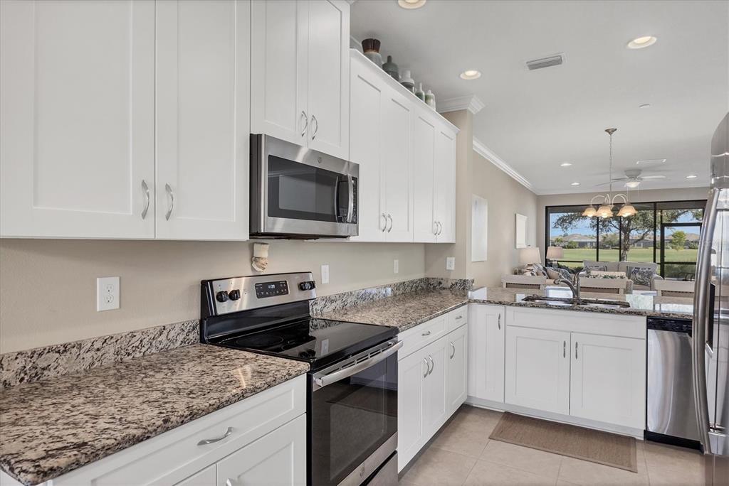 13703 Messina Loop, Unit 104 Bradenton, FL 34211 - Photo 16 of 86 a kitchen with granite countertop white cabinets white stainless steel appliances and a sink