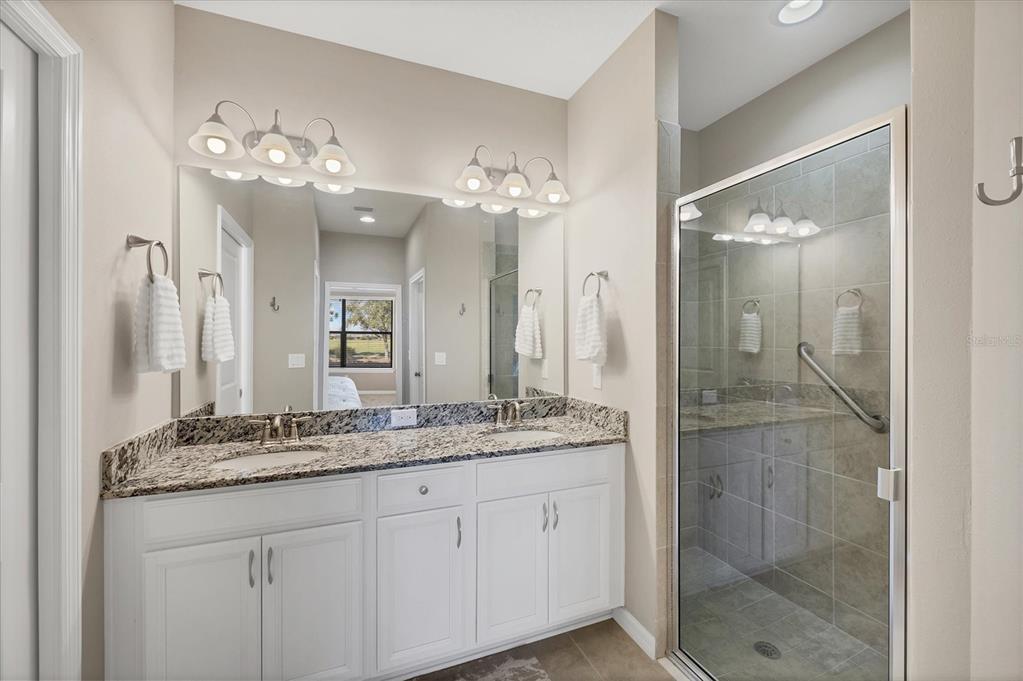 13703 Messina Loop, Unit 104 Bradenton, FL 34211 - Photo 23 of 86 a bathroom with a granite countertop shower sink and mirror
