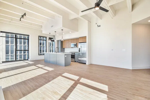 a view of a kitchen with kitchen island wooden floor center island and stainless steel appliances