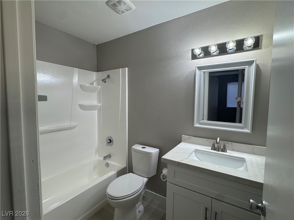 7447 Palermo Avenue Las Vegas, NV 89147 - Photo 16 of 26 Full bathroom featuring a textured wall, vanity, and tub / shower combination