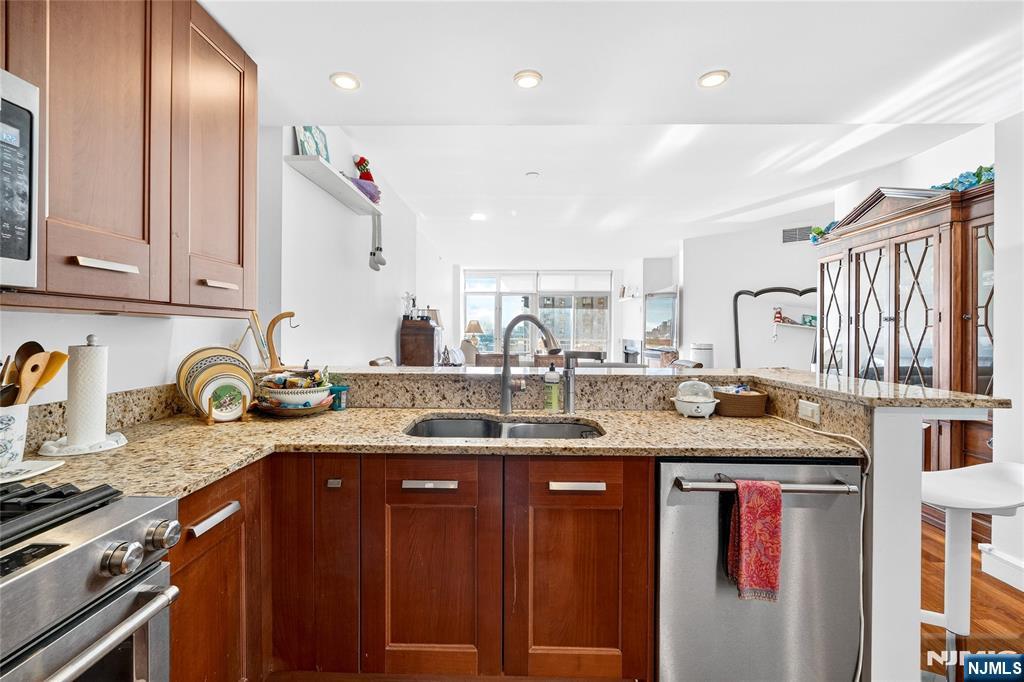 8100 River Road, Unit 801 North Bergen, NJ 07047 - Photo 24 of 48 a kitchen with stainless steel appliances granite countertop a sink stove and cabinets