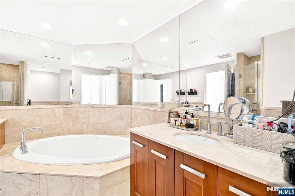 8100 River Road, Unit 801 North Bergen, NJ 07047 - Photo 35 of 48 a bathroom with a double vanity sink a mirror and a bathtub