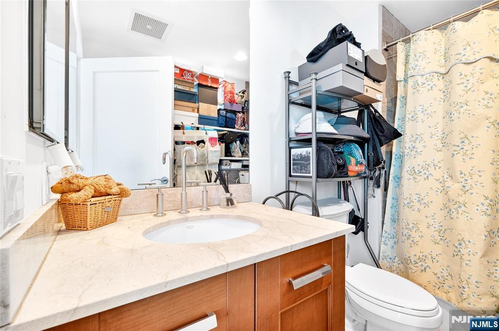 8100 River Road, Unit 801 North Bergen, NJ 07047 - Photo 42 of 48 a bathroom with a sink a toilet and shower curtain