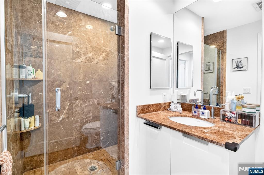 8100 River Road, Unit 801 North Bergen, NJ 07047 - Photo 44 of 48 a bathroom with a granite countertop sink a mirror and shower