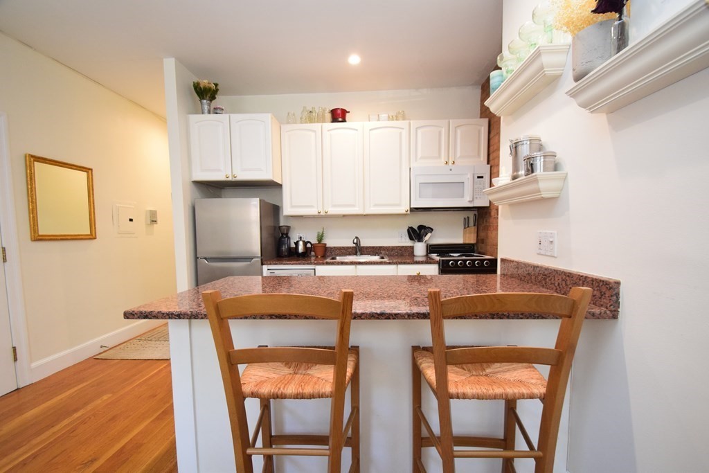 20 Concord Square, Unit 2 Boston, MA 02118 - Photo 7 of 16 a kitchen with stainless steel appliances granite countertop a sink refrigerator and cabinets