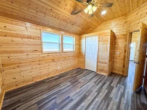 323 Blue Cat Boulevard Haskell, TX 79521 - Photo 8 of 18 Interior room featuring wood-plank walls and a vaulted wood-plank ceiling