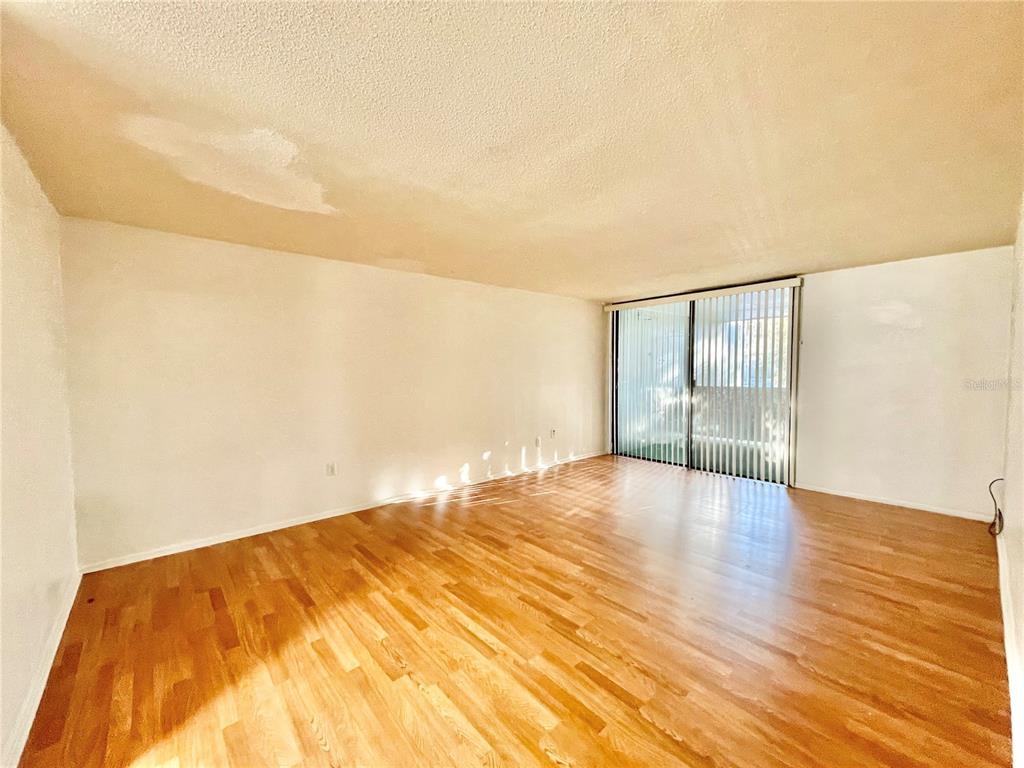 719 Southwest 75th Street, Unit 103 Gainesville, FL 32607 - Photo 12 of 39 a view of empty room with wooden floor and fan
