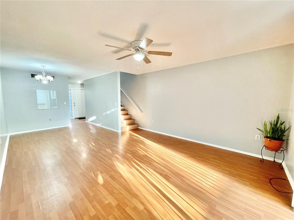 719 Southwest 75th Street, Unit 103 Gainesville, FL 32607 - Photo 9 of 39 a view of a room with wooden floor and a ceiling fan