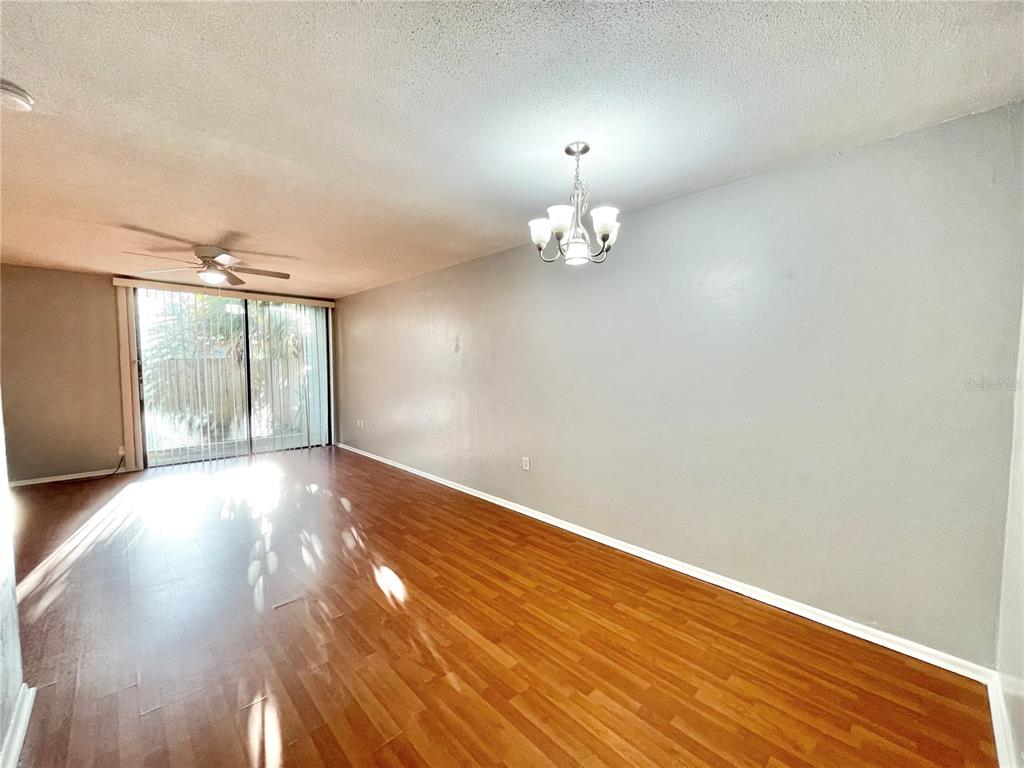 719 Southwest 75th Street, Unit 103 Gainesville, FL 32607 - Photo 10 of 39 a view of empty room with wooden floor and fan