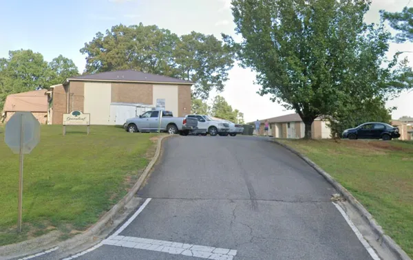 a front view of a house with a yard and trees