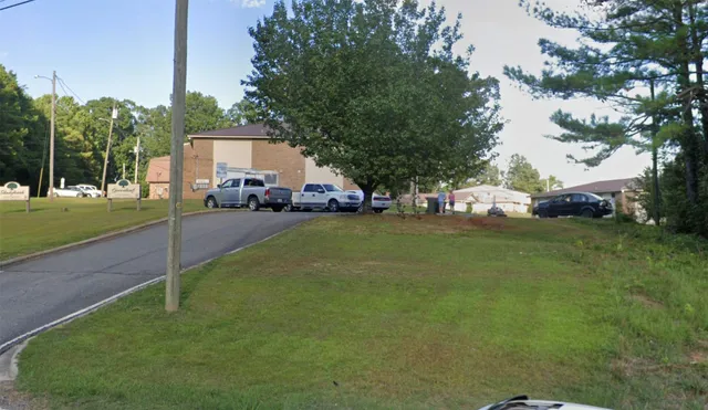 a view of a house with a backyard and a tree