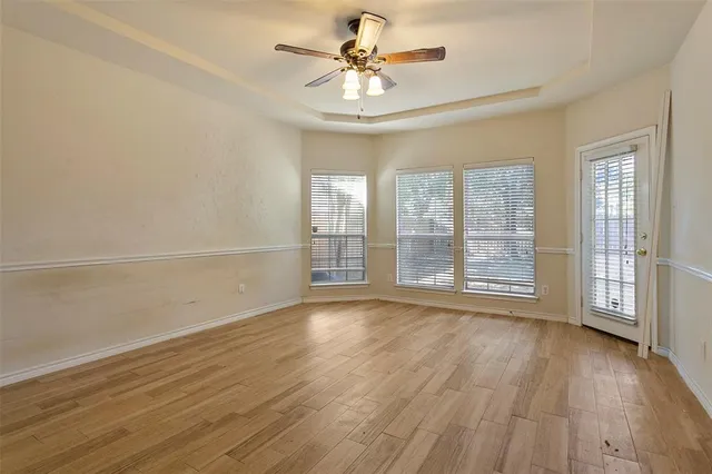 a view of an empty room with a window and wooden floor