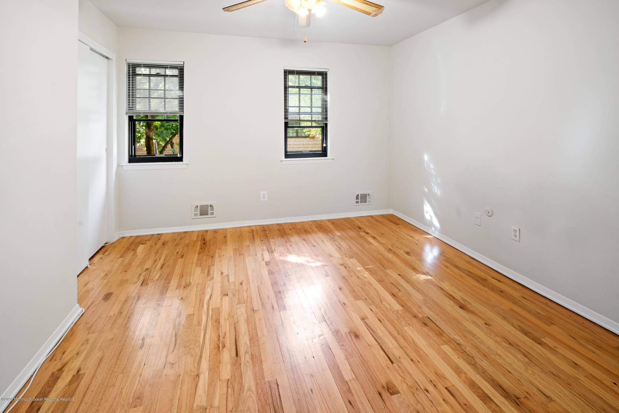 321 Spring Street, Unit 29 Red Bank, NJ 07701 - Photo 14 of 21 an empty room with wooden floor cabinet and windows