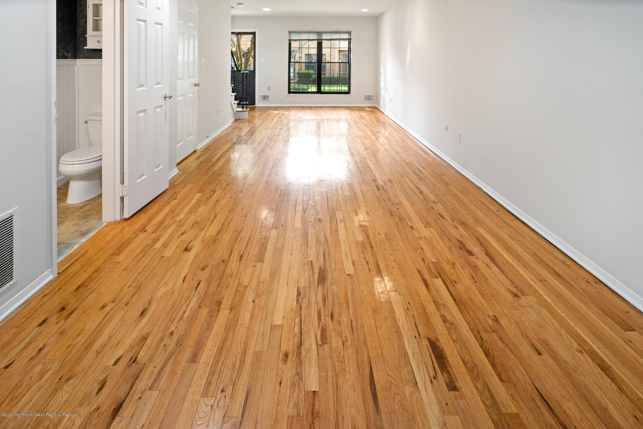 321 Spring Street, Unit 29 Red Bank, NJ 07701 - Photo 7 of 21 a view of an empty room with wooden floor and a window