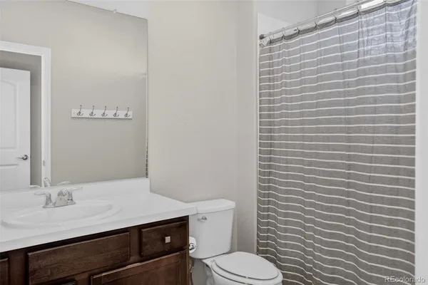 a bathroom with a granite countertop toilet and a sink