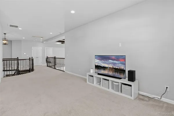 a living room with furniture a flat screen tv and a table