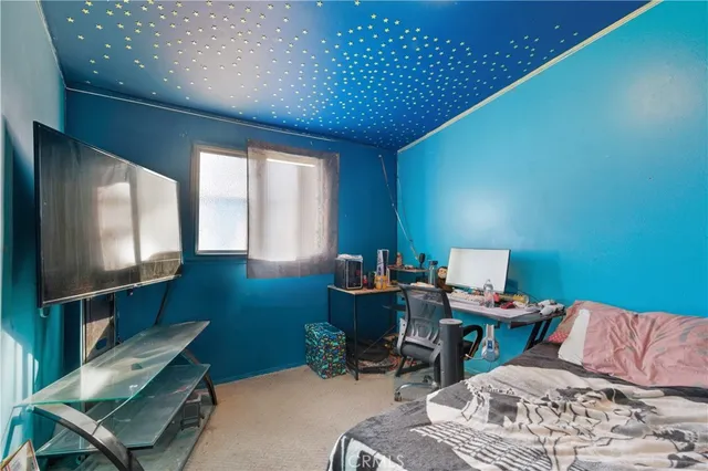 a bedroom with furniture and a flat screen tv