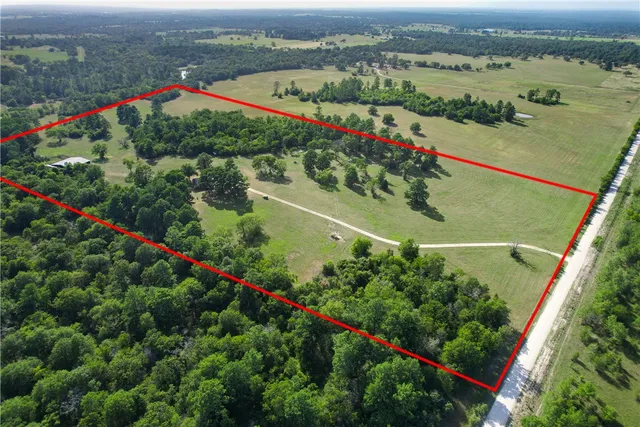 an aerial view of a houses with a lush green forest