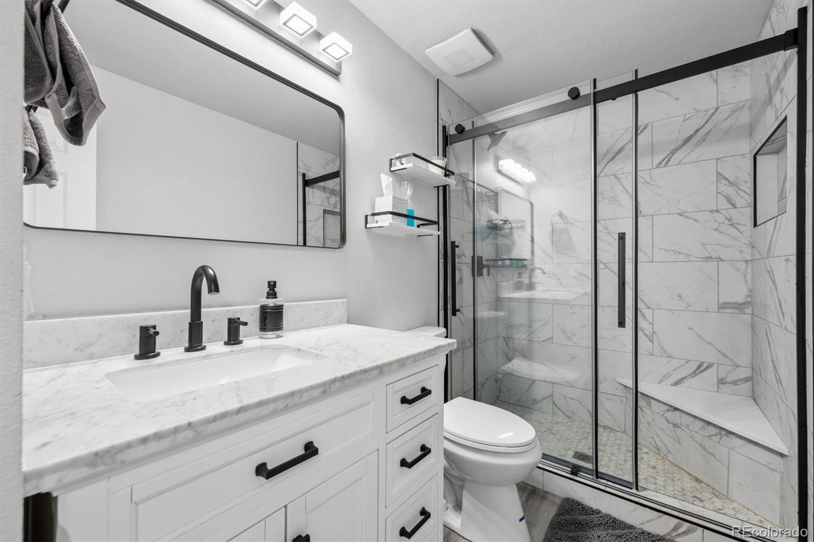 10433 Garrison Street Broomfield, CO 80021 - Photo 17 of 30 a bathroom with a granite countertop sink toilet and shower