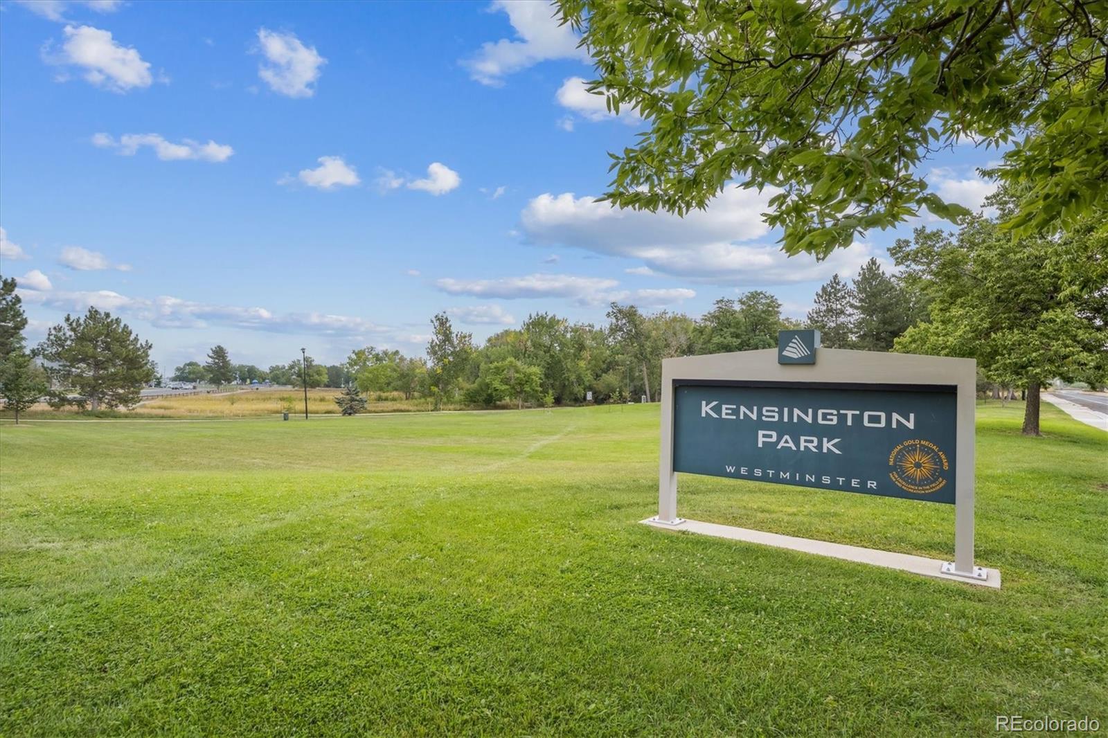 10433 Garrison Street Broomfield, CO 80021 - Photo 27 of 30 a sign that is sitting in the grass near a building