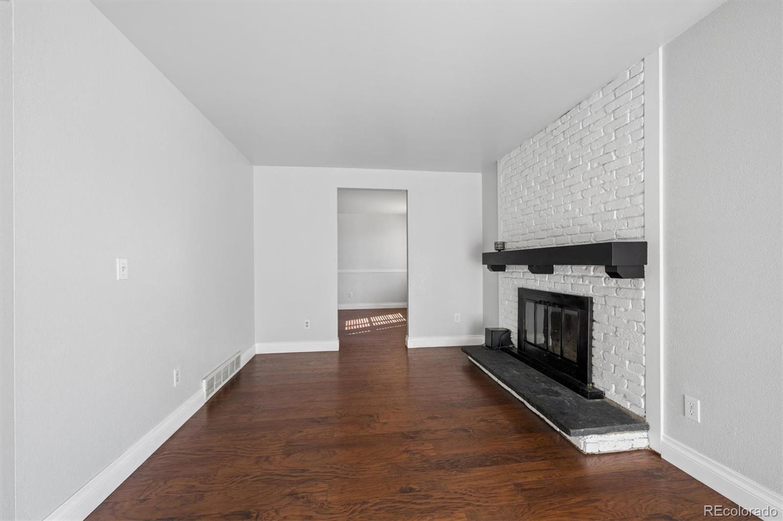 10433 Garrison Street Broomfield, CO 80021 - Photo 5 of 30 a view of an empty room with wooden floor fireplace and a window