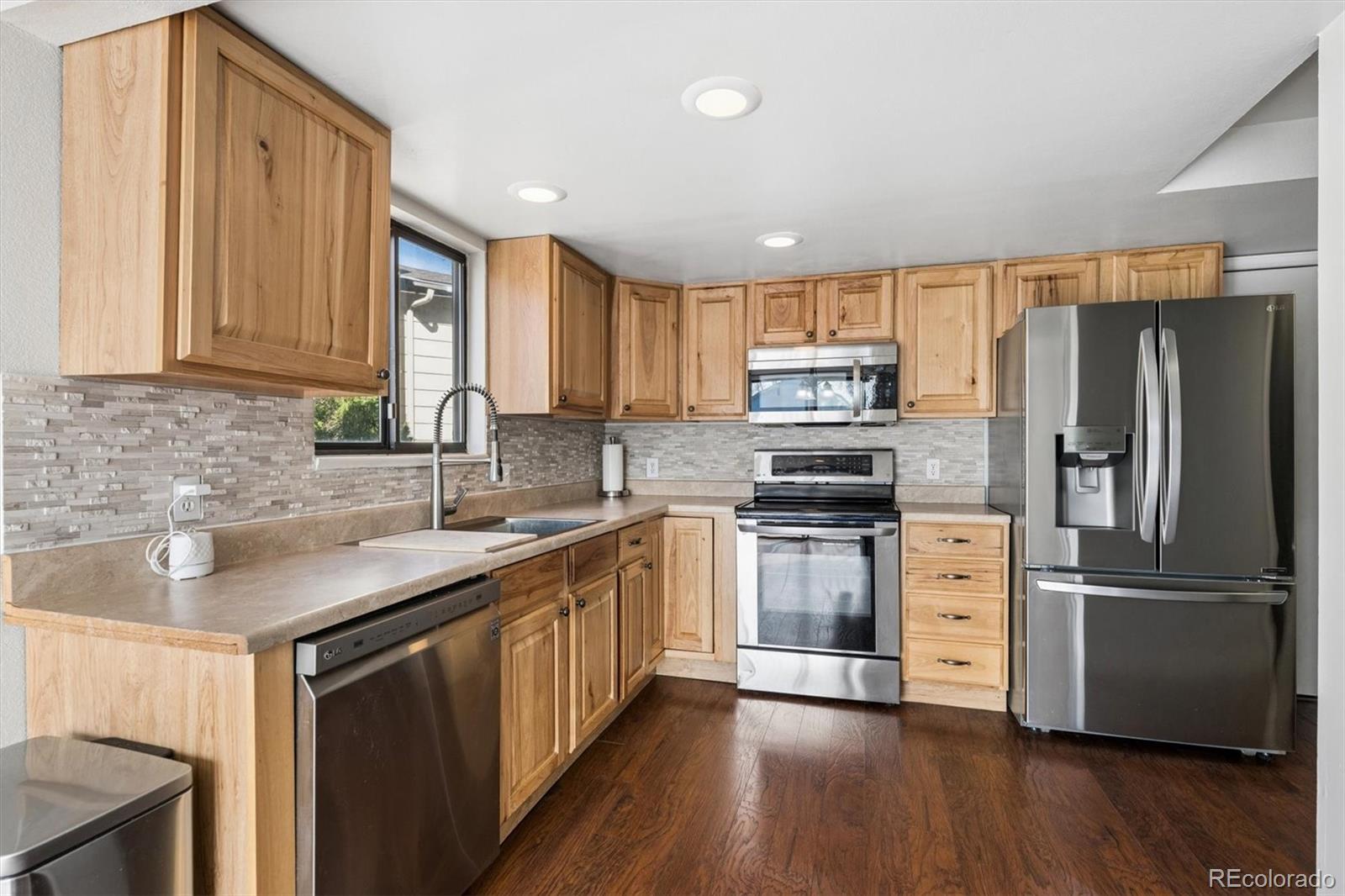 10433 Garrison Street Broomfield, CO 80021 - Photo 8 of 30 a kitchen with stainless steel appliances granite countertop a refrigerator stove and sink