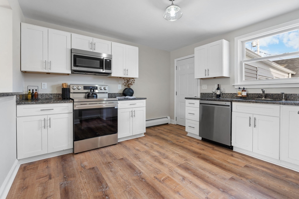 368 Read Street Somerset, MA 02726 - Photo 10 of 35 a kitchen with stainless steel appliances granite countertop a stove top oven a sink dishwasher and white cabinets with wooden floor