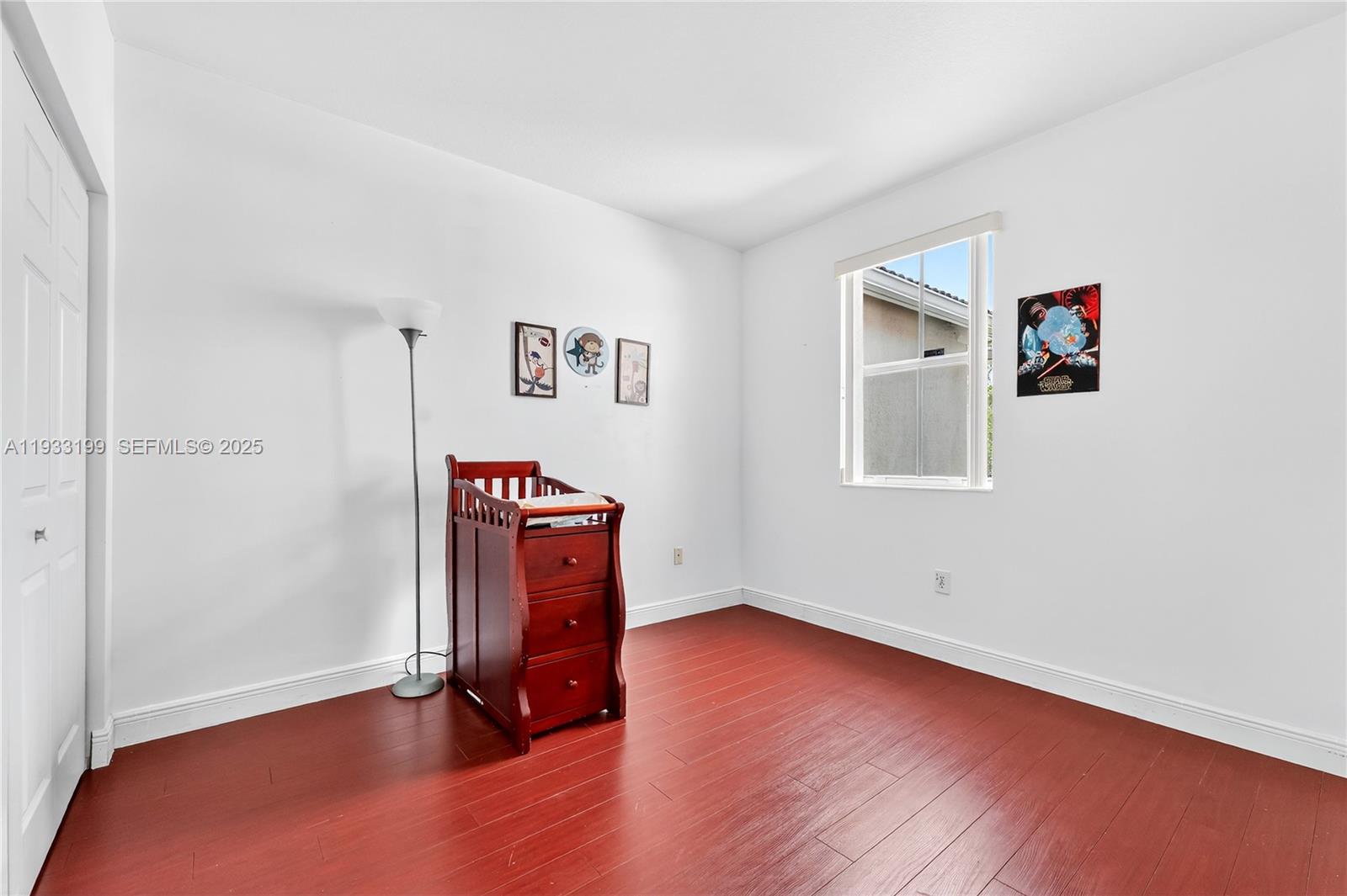 10934 Southwest 247th Terrace Homestead, FL 33032 - Photo 13 of 28 an empty room with wooden floor and windows