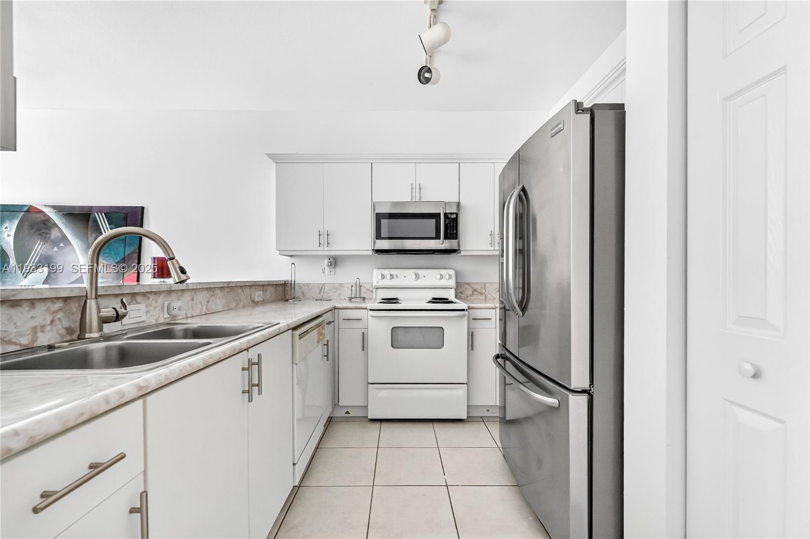 10934 Southwest 247th Terrace Homestead, FL 33032 - Photo 3 of 28 a kitchen with a sink cabinets and stainless steel appliances