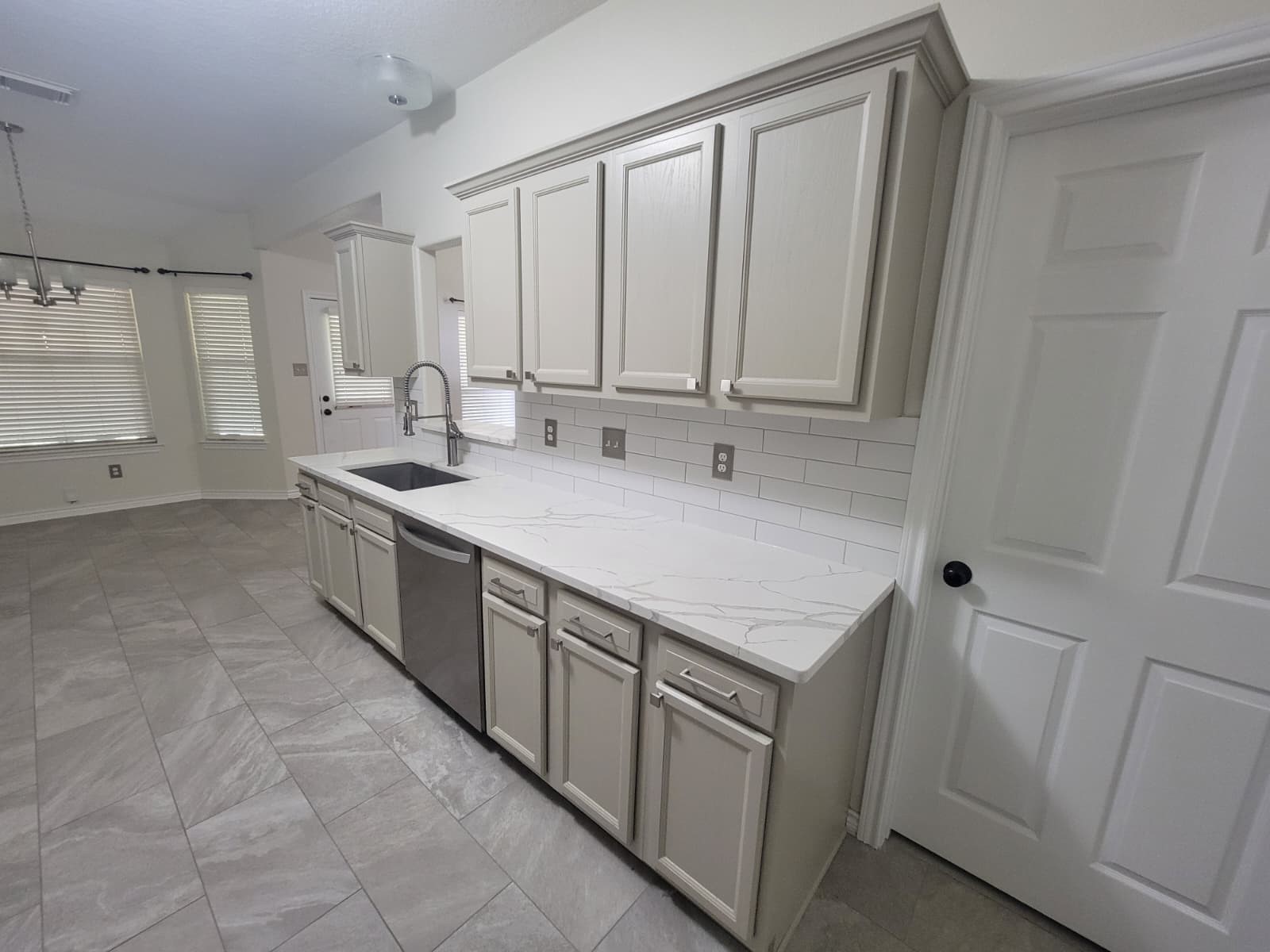 320 Old San Felipe Road Sealy, TX 77474 - Photo 8 of 12 Modern kitchen with sleek cabinets, stylish tile flooring, and a spacious layout featuring a stainless steel dishwasher and elegant countertops.