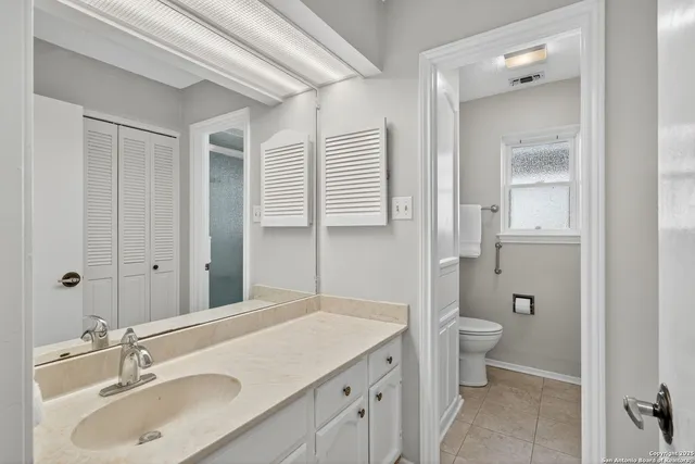 a bathroom with a granite countertop sink toilet and shower