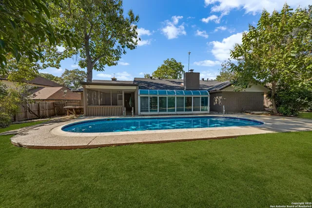 a view of a swimming pool with a sitting area and garden