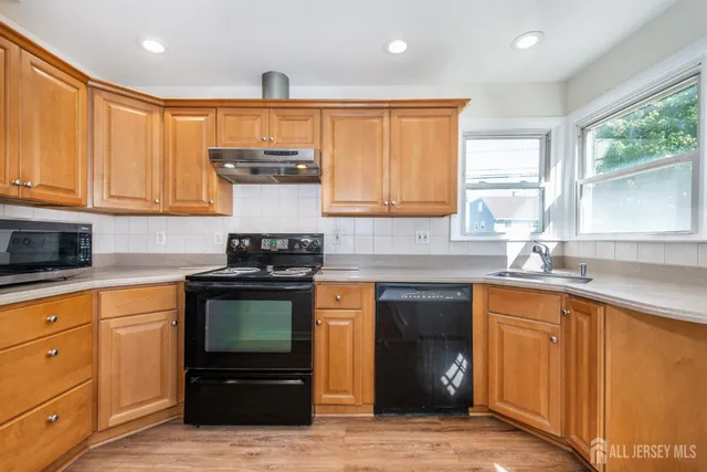 a kitchen with stainless steel appliances granite countertop a stove sink and cabinets