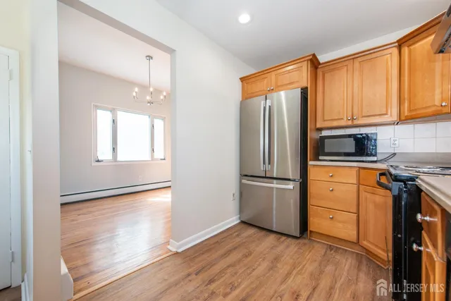 a kitchen with granite countertop wooden floors and stainless steel appliances