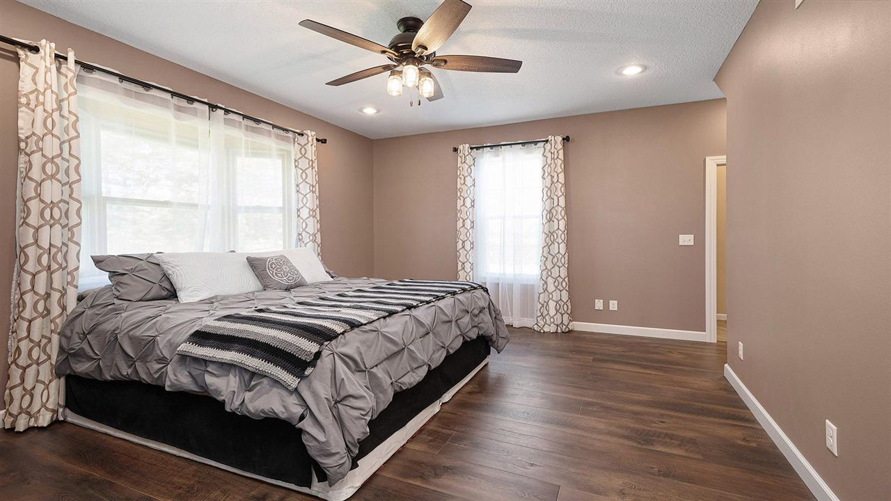 1652 South Columbian Road Oregon, IL 61061 - Photo 15 of 40 a bedroom with a large bed and a chandelier