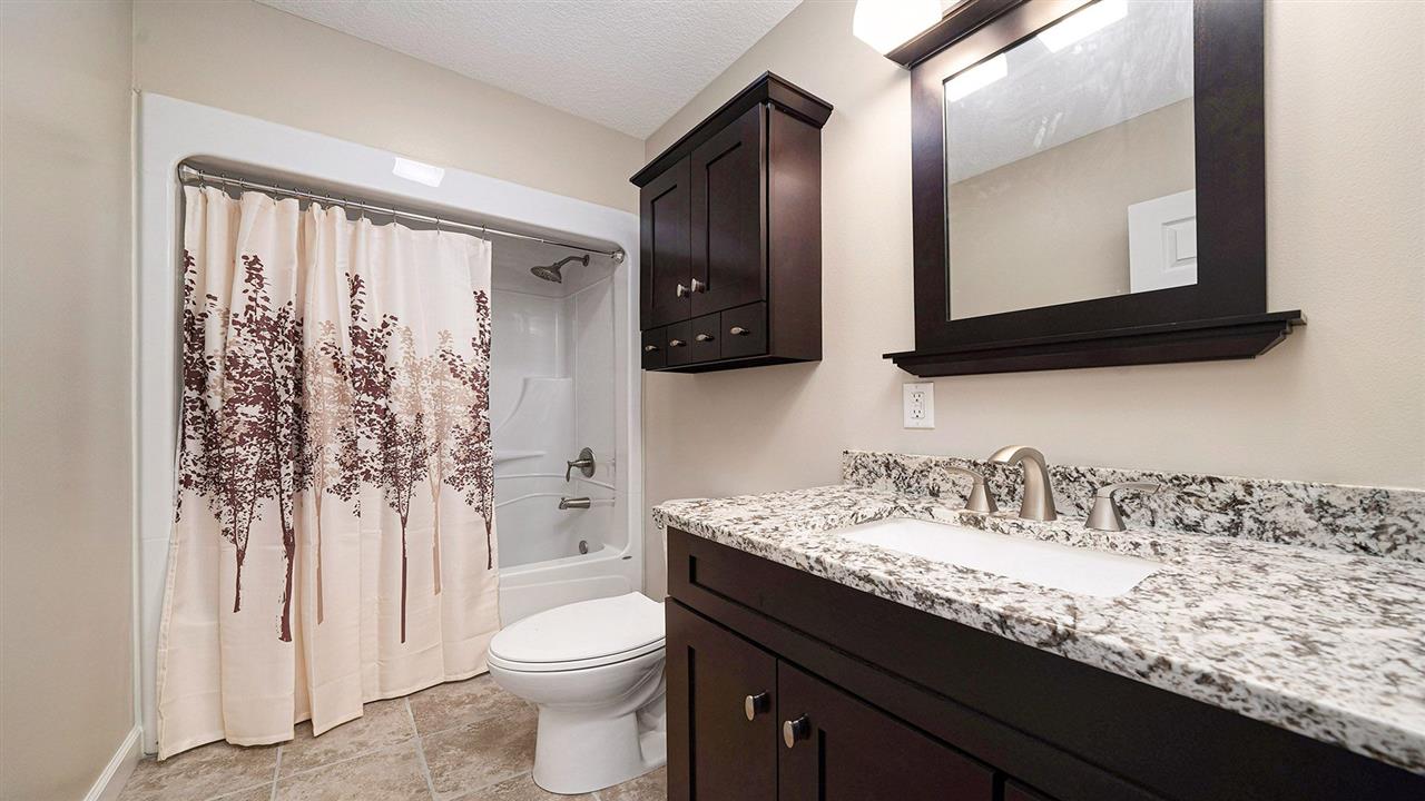 1652 South Columbian Road Oregon, IL 61061 - Photo 23 of 40 a bathroom with a granite countertop sink toilet and mirror