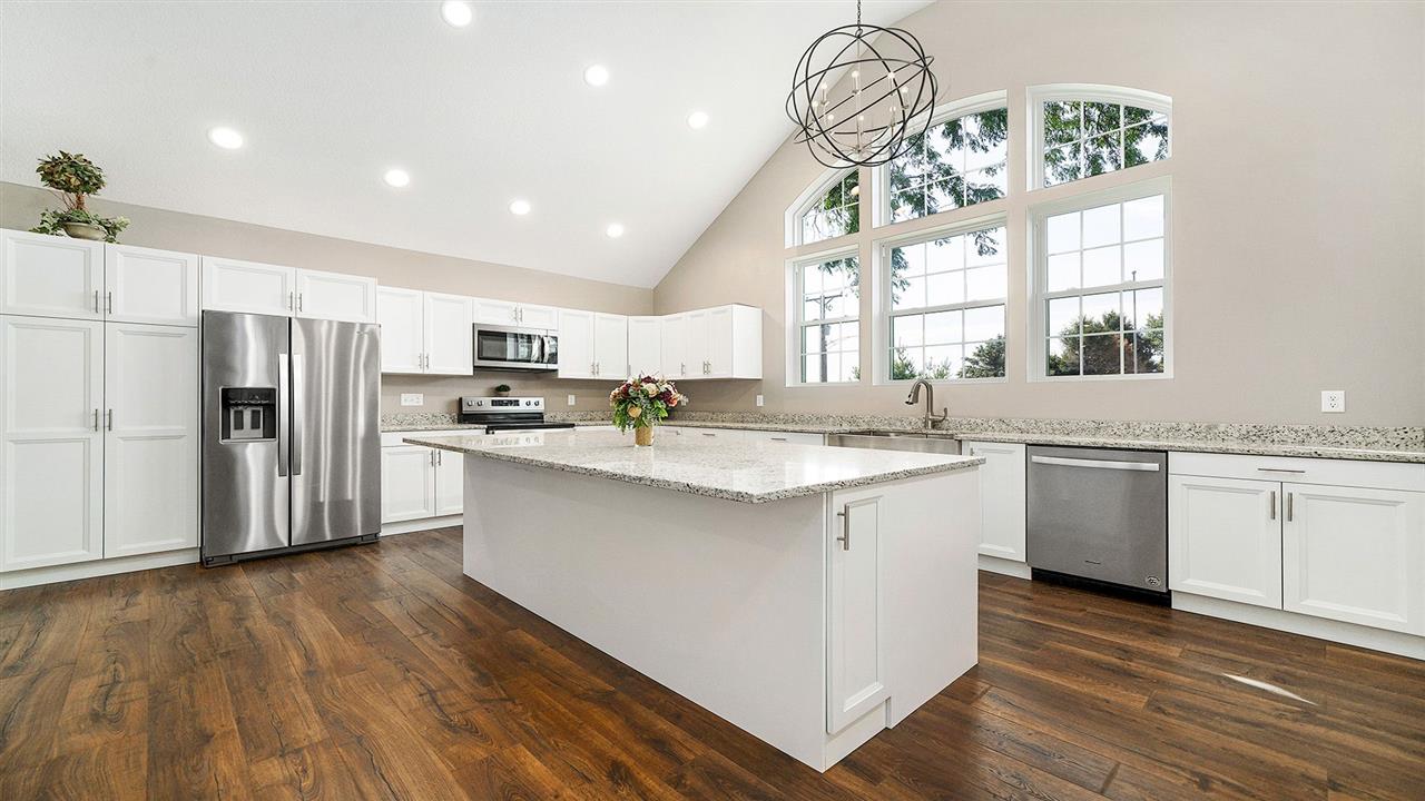 1652 South Columbian Road Oregon, IL 61061 - Photo 7 of 40 a kitchen with stainless steel appliances a white refrigerator a sink dishwasher a stove and a chandelier
