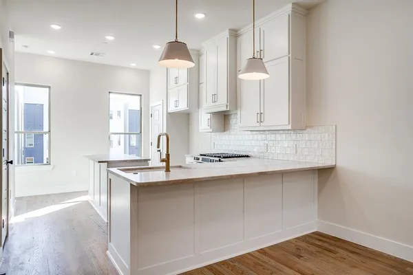 a kitchen with kitchen island a sink stainless steel appliances and cabinets