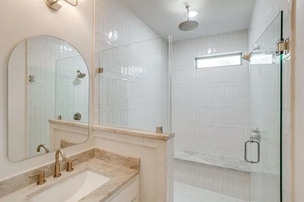 a bathroom with a granite countertop sink a shower and a mirror