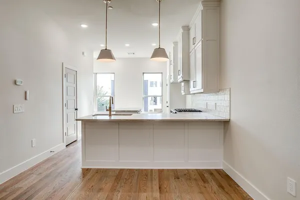 a kitchen with wooden floor and window