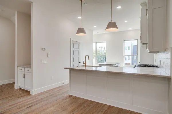 a large kitchen with granite countertop a sink a counter space appliances and cabinets