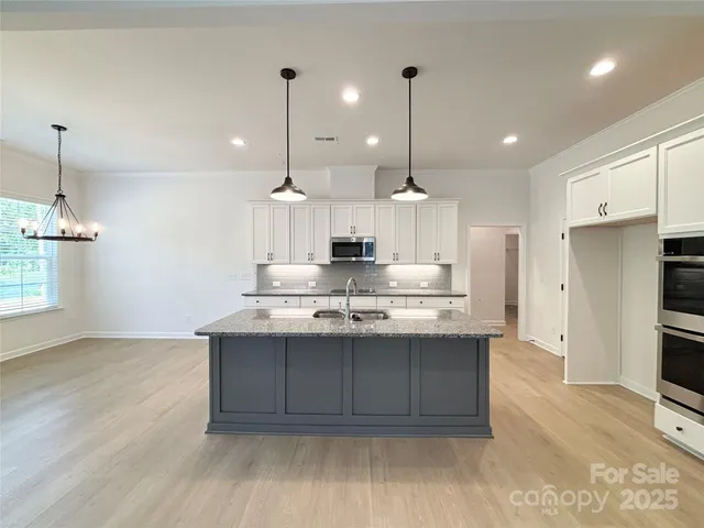 a kitchen with kitchen island a sink stainless steel appliances and cabinets